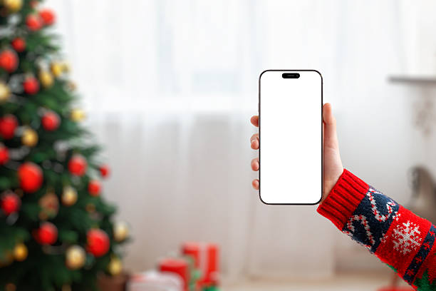 istock Blank phone screen mockup in a cozy Christmas setting, ideal for holiday designs, mobile apps, seasonal promotions and festive marketing visuals 2249007984