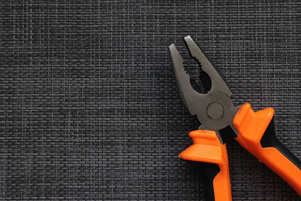 istock Orange handled combination pliers on dark background 2249009301