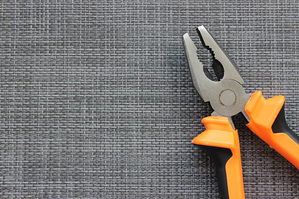 istock Orange handled combination pliers on dark background 2249009310