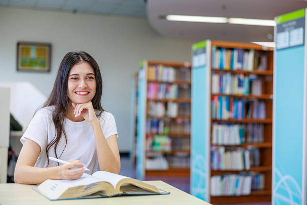 istock Caucasian female student reading a book alone in a quiet library, capturing education, concentration, and academic lifestyle. Ideal for themes about studying, learning environments, school marketing, and personal development. 2249010144