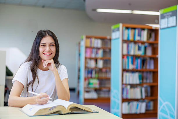 istock Caucasian female student reading a book alone in a quiet library, capturing education, concentration, and academic lifestyle. Ideal for themes about studying, learning environments, school marketing, and personal development. 2249010168