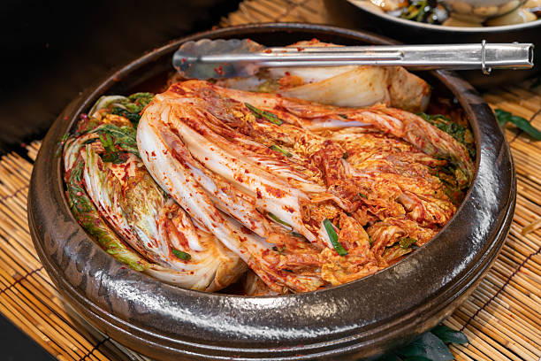 Traditional Korean Napa cabbage kimchi made with chili pepper flakes, garlic, ginger, and fish sauce, fermented to develop a rich spicy and tangy flavor, served as a classic Korean side dish.