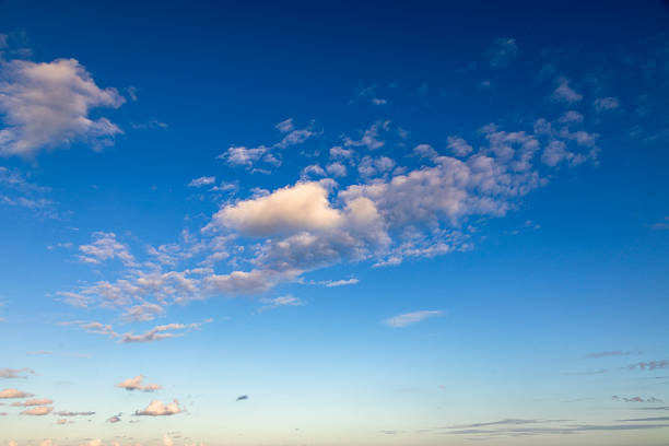 A tranquil view of scattered clouds floating across a vibrant blue sky above Lauderdale-by-the-Sea.