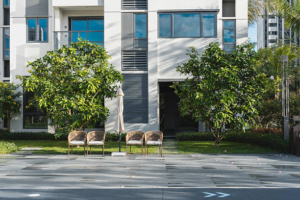 istock Two empty chairs placed on paved patio in front of modern apartment building, concept of outdoor relaxation and leisure lifestyle in residential community. 2249015983