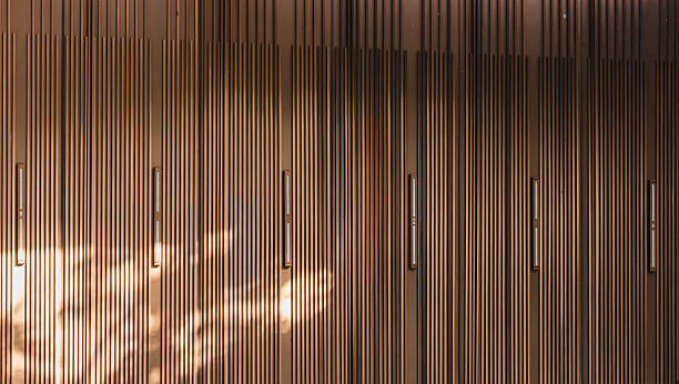 Full frame background texture of modern vertical brown wooden or metal slats, architectural facade pattern design.