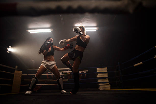 istock Female boxing match in gym ring at night 2249016993