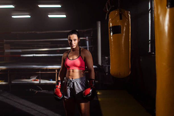 istock Female boxer standing in training gym with gloves 2249017034