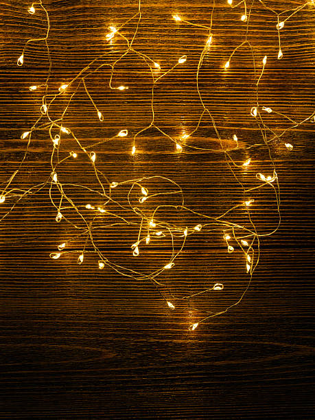 istock Garland glows yellow on a brown wooden background. 2249017366