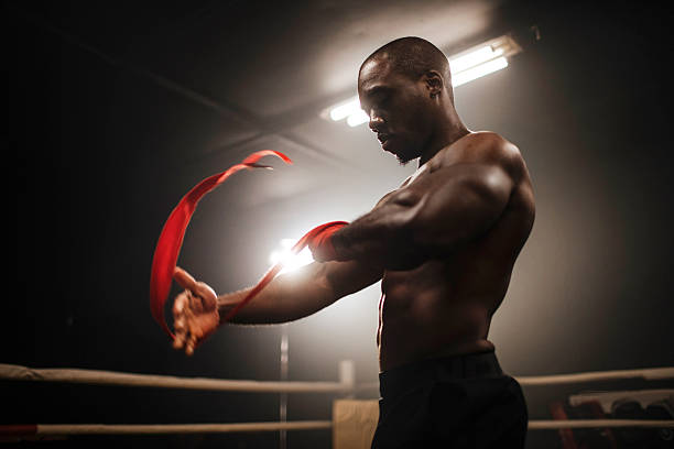 istock Muscular boxer twisting red ribbon in ring 2249017595