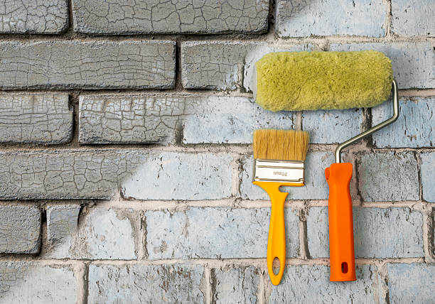 istock Creative background for renovation. Roller and brush against a gray brick background. Renovation tools 2249022382