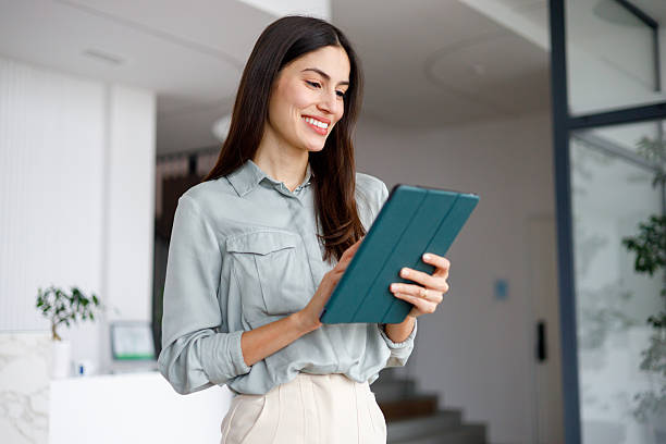 istock Businesswoman using digital tablet in modern office, smiling, managing tasks and operations 2249023670
