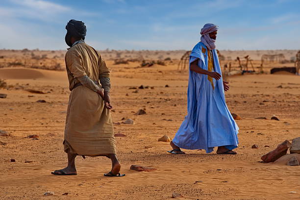 Portrait of a berber man wearing a turban and traditional clothing, sitting in the sahara desert