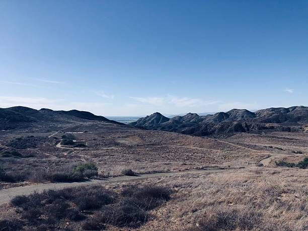 istock Stunning View of Rolling Hills and Distant Mountains Under a Bright Blue Sky in a Tranquil Landscape During Daytime 2249025891