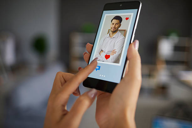 istock Female finger pushing chat button on smartphone using dating app to find love 2249029245