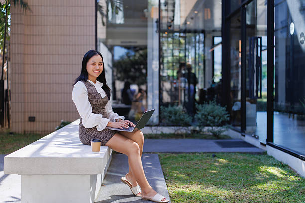 istock Young woman remotely working on laptop from urban outdoor setting 2249031708