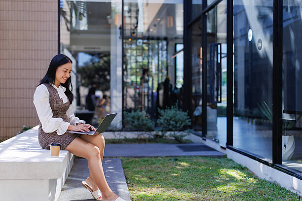 istock Young woman working on laptop outdoors at cafe 2249031721