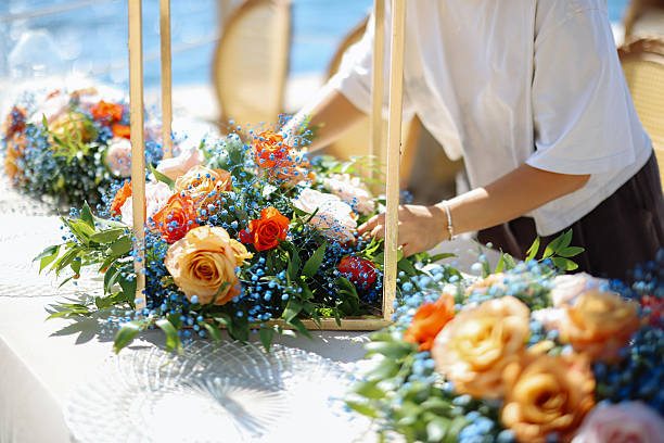 Shot of a young woman decorating a table with place card holders in preparation for a wedding reception