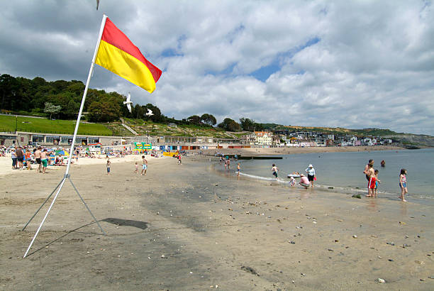 Dorset - England British Beaches Lyme Regis, Dorset west beach with lifeguard on duty flag United Kingdom 2025