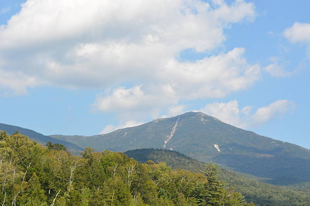 istock Majestic Mountain Peak Rises Above Lush Green Trees Under a Bright Blue Sky 2249037831