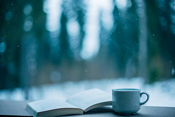 Steaming mug of coffee next to an open book creating a cozy winter reading scene