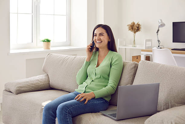 istock Smiling woman relax on sofa talking on smartphone 2249042307