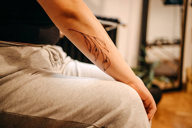 caucasian plus size woman in pink jacket in the city showing her tattoo on the forearm