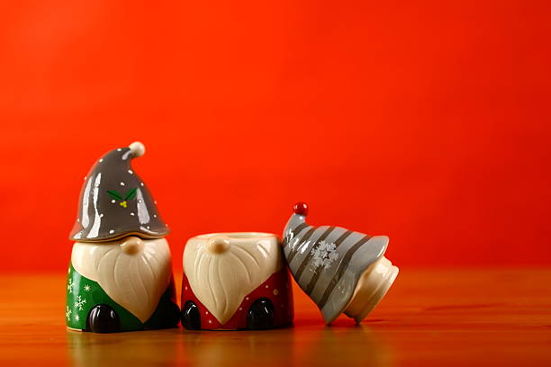 Colorful fairy-tale dwarfs made of plasticine on the background of burning candles.