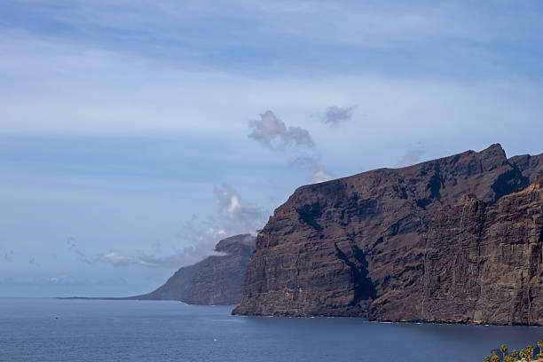 Coast of Atlantic ocean with cliffs Los Gigantes. Blue sky with white clouds in the autumn. Tenerife, Canary Islands, Spain.