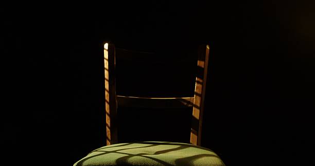 istock Wooden Chair with Shadows in Dramatic Lighting 2249058252
