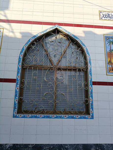 Traditional mosque window captured from outside showing geometric patterns, spiritual ambiance, and elegant Islamic architectural craftsmanship
