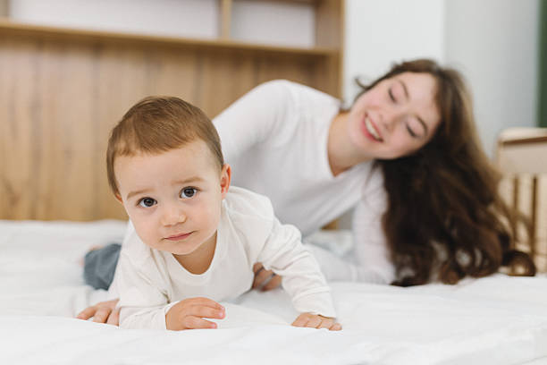 istock Young mother playing with her baby at home 2249066109