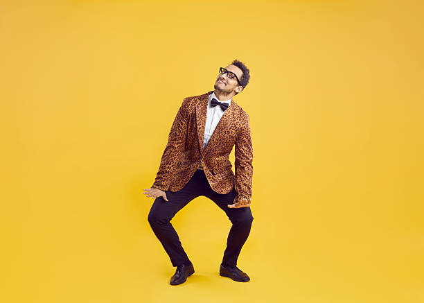istock Happy funny goofy African American man in leopard jacket dancing on yellow studio background 2249069119