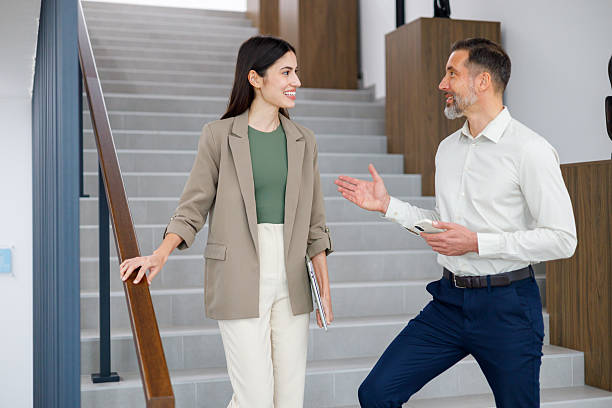 istock Business colleagues having a conversaton and smiling on office stairs, discussing projects and strategy 2249071990