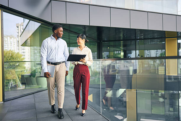 istock Business colleagues walking and discussing work at modern office building 2249078336