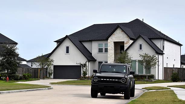 Houston, TX USA November 23, 2025 -  A Luxury home and Ford Bronco in a prestigious neighborhood, featuring elegant architecture, manicured landscaping, and timeless upscale design.