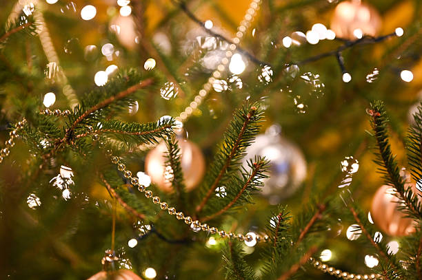 istock Close up of Christmas tree branches with festive lights and ornaments 2249081017
