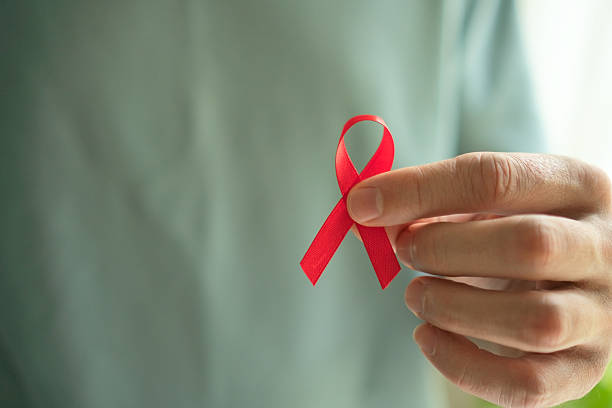 istock Red HIV Support Ribbon in Man's Hand 2249081773