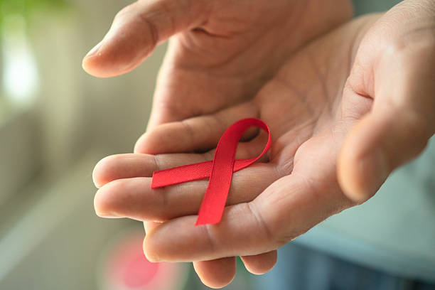 istock Man Presenting Red Ribbon for World AIDS Day 2249081811