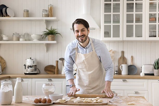 istock Portrait joyful man in apron smiling at camera flattening dough 2249082761