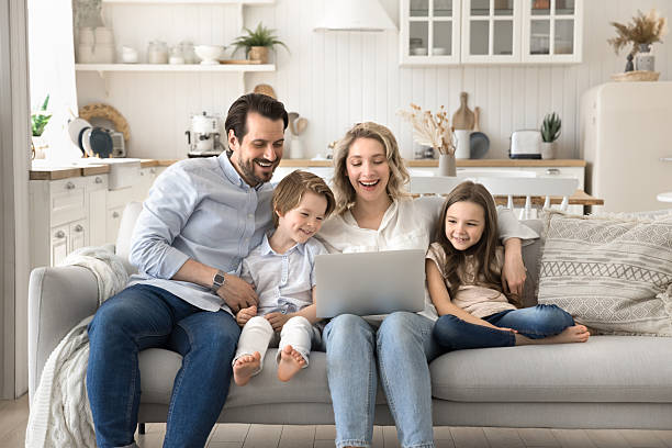istock Joyful laughing couple with small children watching videos on notebook 2249083379