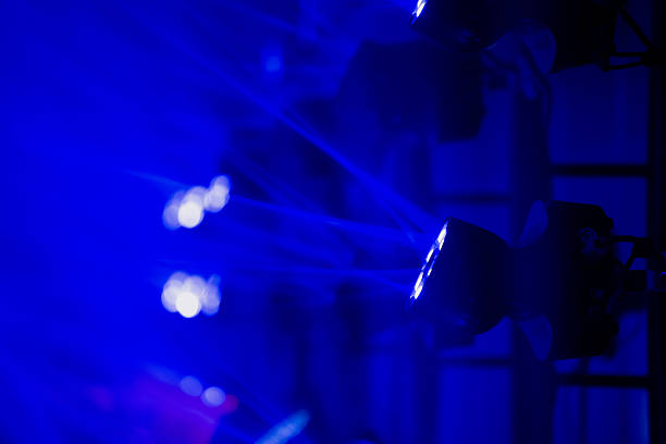 Blue stage beams shining from multiple LED fixtures on structured rigging, showcasing precision lighting technology in contemporary entertainment industry setups