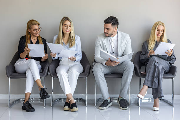 istock Candidates participating in a job interview at a modern office in the morning while reviewing resumes 2249086564