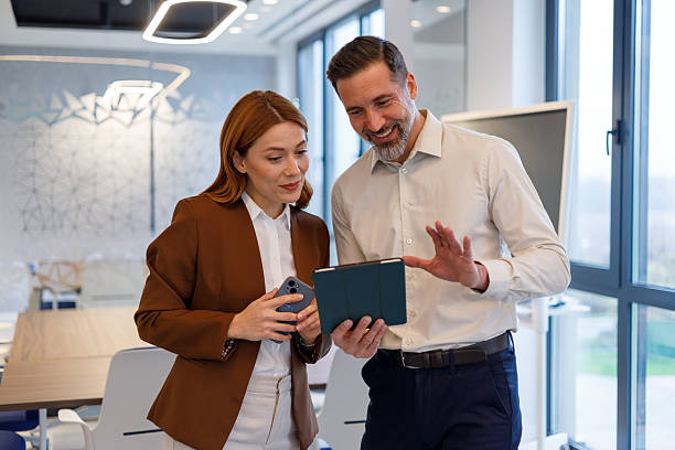 istock Business colleagues collaborating on project showing information on digital tablet and smartphone in modern office 2249089424