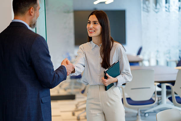 istock Business professionals shaking hands, establishing partnership and agreement in a modern office 2249091716
