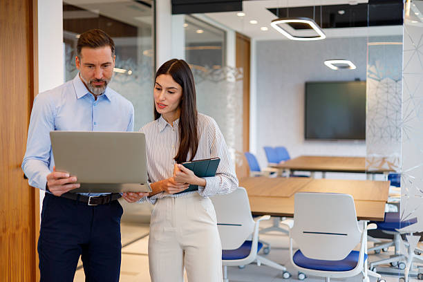 istock Two professionals in a modern meeting room, analyzing project information on a laptop 2249092335