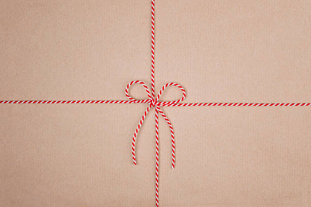 Red and White Christmas String Tied in Bow on Kraft Paper Background