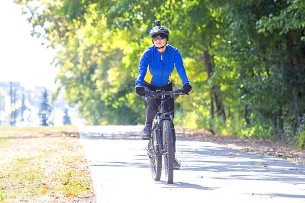 istock Cyclist on a sunny day riding along a tree-lined path in autumn 2249096763