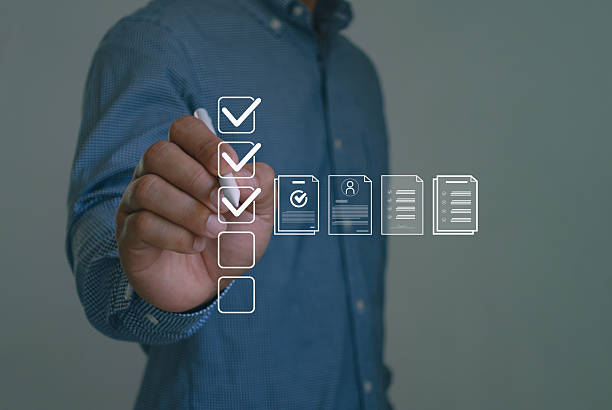 istock Businessman mark off items on digital checklist, representing quality assurance and document control processes, verification and compliance. Quality Assurance and Document Control with Checklist Icon. 2249097740