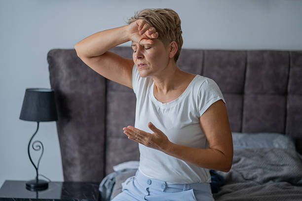 istock A woman with migraine sitting on her bed 2249099240