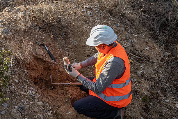 istock Geologist searching for and examining minerals in an open-air quarry. Tools, hammer... a precious piece of mineral. Geology in winter. 2249099543